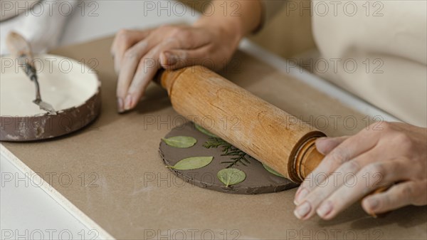 Close up hands using rolling pin