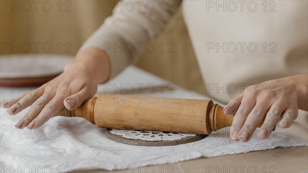 Close up hands with rolling pin