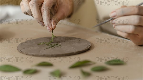 Close up hands working with plant clay