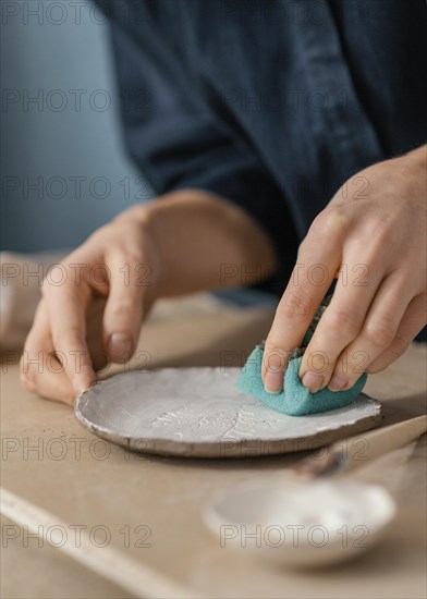 Close up hand using blue sponge