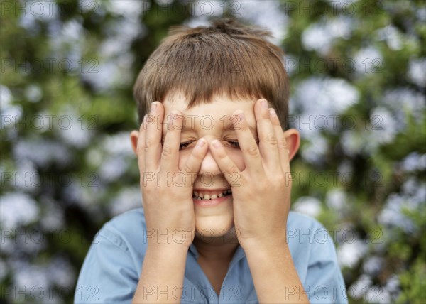 Close up kid covering his face