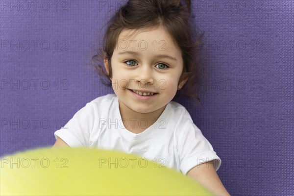 Close up smiley kid holding gym ball