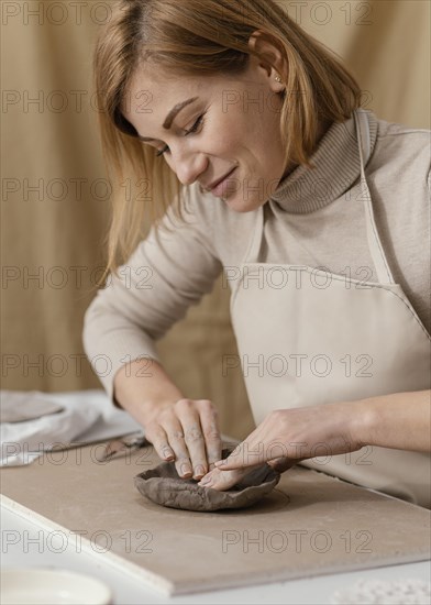 Close up smiley woman doing pottery