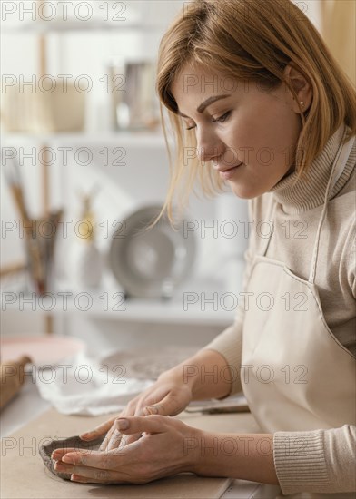 Close up smiley woman doing pottery indoors