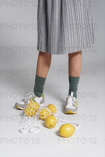 Close up turtle bag with lemons beside woman feet