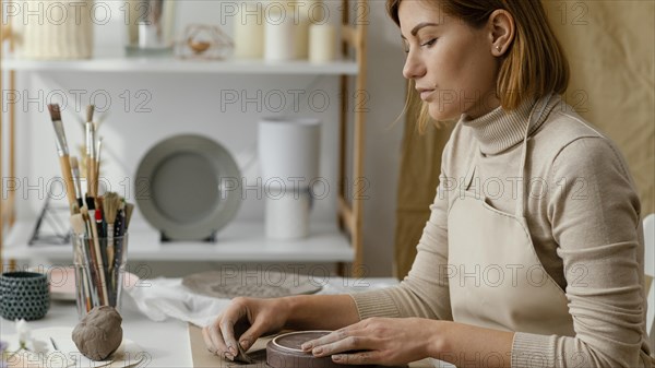 Close up woman doing pottery home