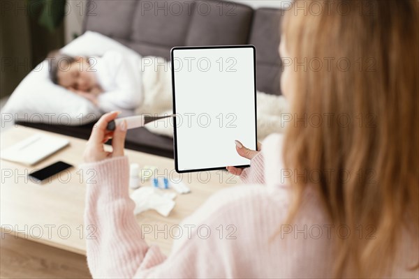 Close up woman holding tablet thermometer