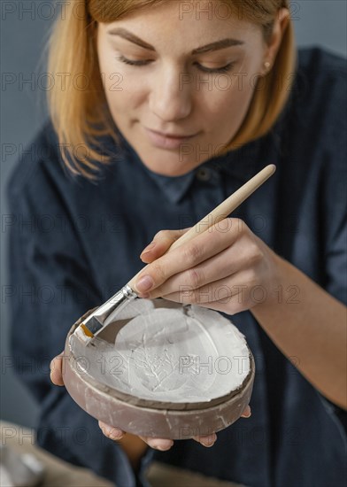 Close up woman painting clay