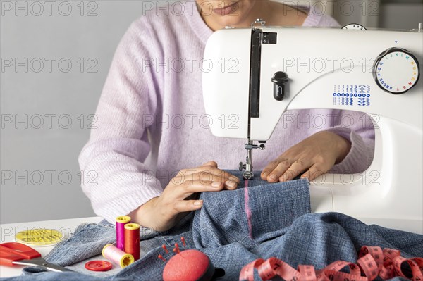 Close up woman sewing with machine