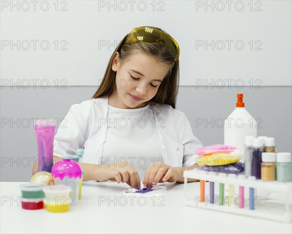 Front view young girl scientist making slime