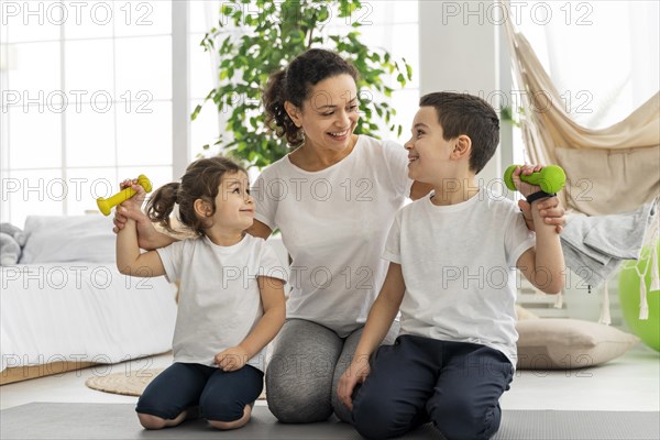 Full shot adult kids with dumbbells