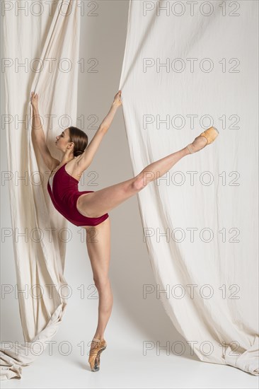 Full shot ballerina standing one leg