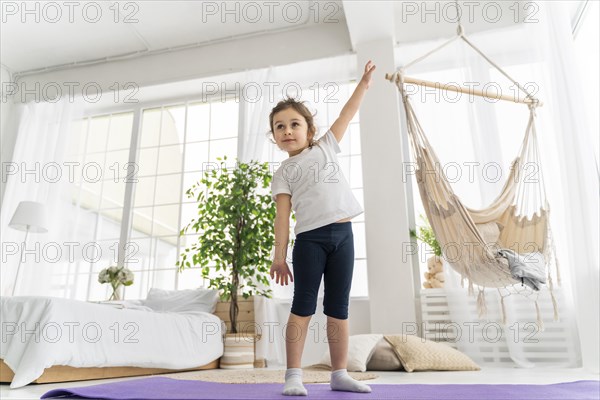 Full shot girl standing yoga mat