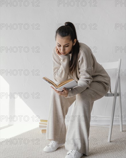 Full shot woman chair reading