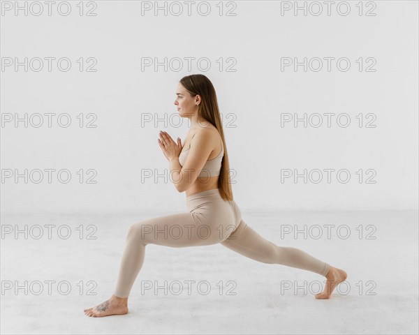 Full shot woman exercising indoors