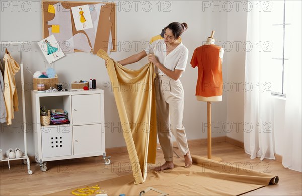 Full shot woman holding fabric