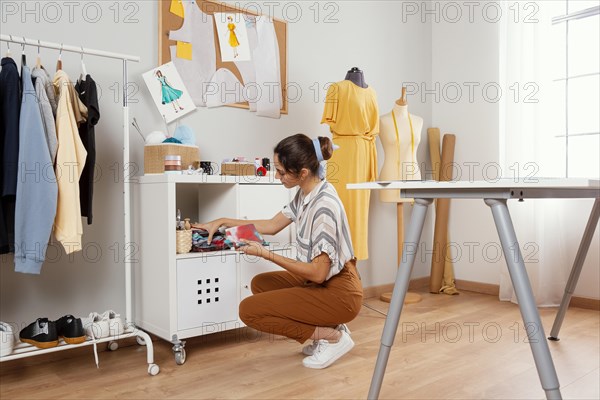 Full shot woman holding fabrics