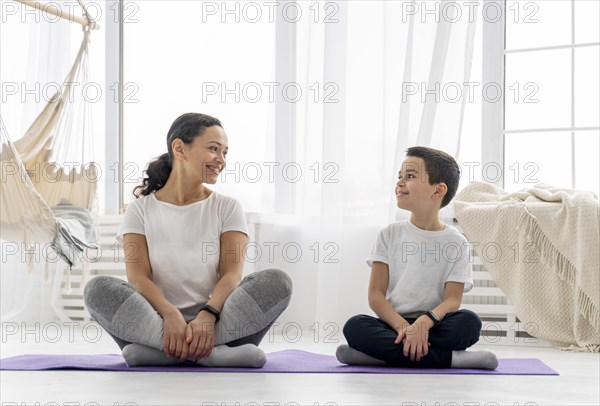 Full shot woman kid sitting mat