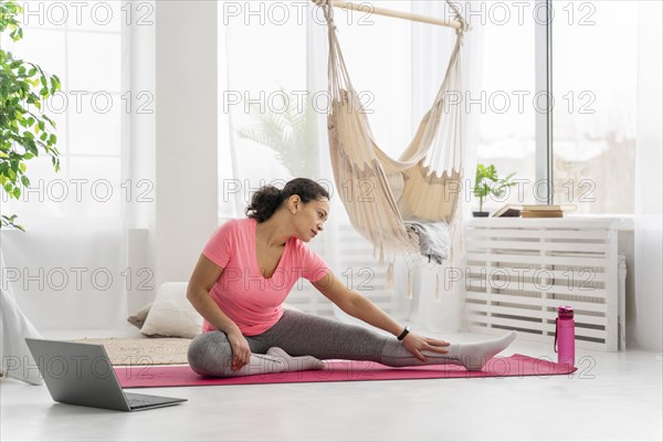 Full shot woman stretching mat 3