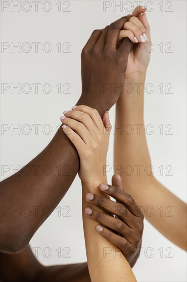 Interracial hands holding each other close up
