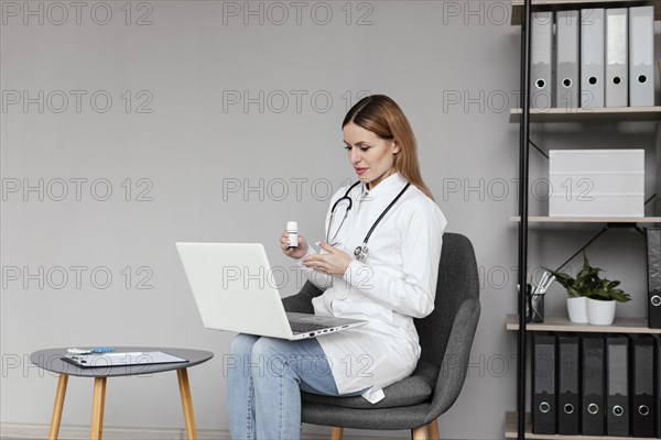 Medium shot doctor sitting with computer
