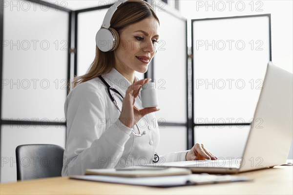Medium shot doctor working with laptop