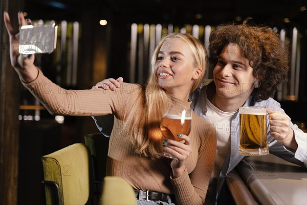 Medium shot friends taking selfie pub