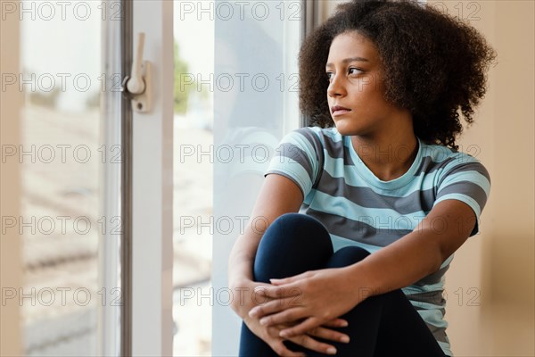 Medium shot girl looking out window