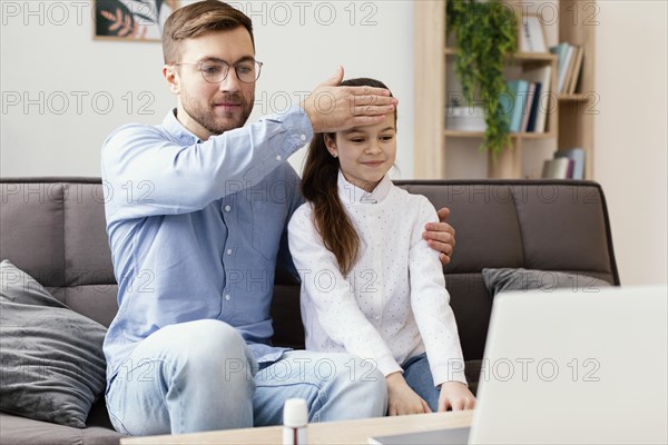 Medium shot man checking girl temperature