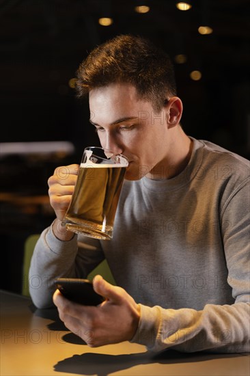 Medium shot man drinking beer pub