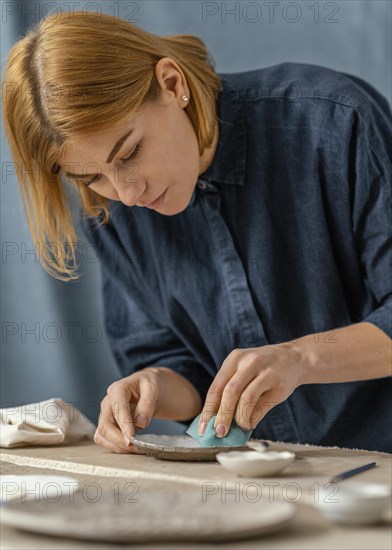 Medium shot woman doing pottery