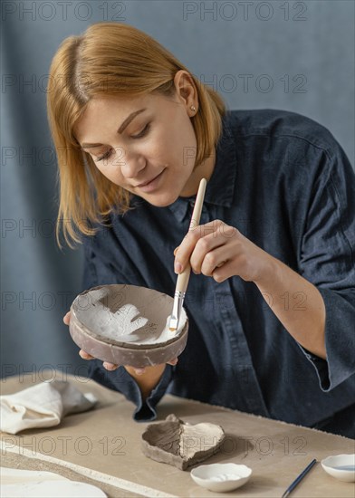 Medium shot woman painting item
