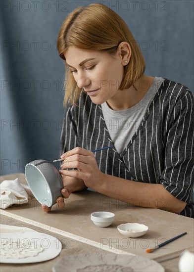 Medium shot woman painting with brush 2