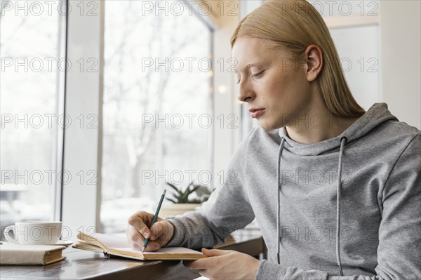 Medium shot woman writing notebook