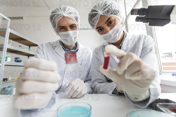 Scientists with tube glass slide close up