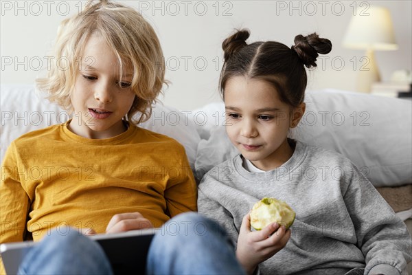 Siblings bed playing mobile tablet 2