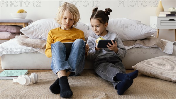 Siblings playing with mobile tablet