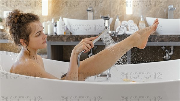Side view woman relaxing bathtub