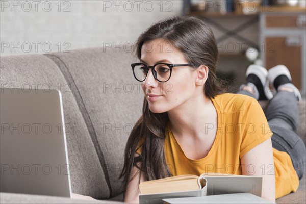 Smart young student with laptop books