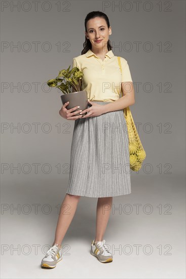 Woman carrying reusable turtle bag holding flower pot