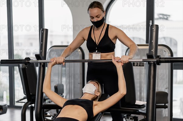 Young woman exercising gym her coach