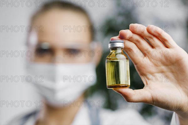 Front view female researcher with vaccine bottle