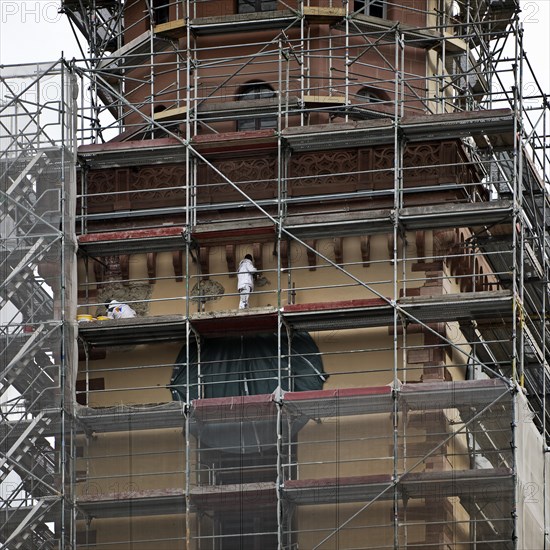 Scaffolded tower of St Catherine's Protestant Church with construction workers