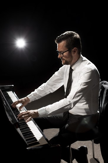 Side view male musician playing piano