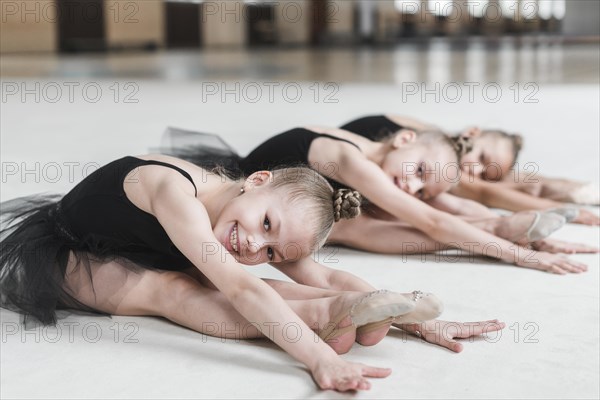 Smiling ballerina girls posing dance floor