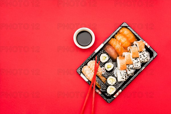 Sushi rolls sashimi tray with soy sauce colored background