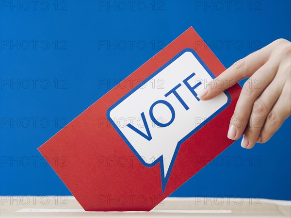 Woman placing her ballot election box