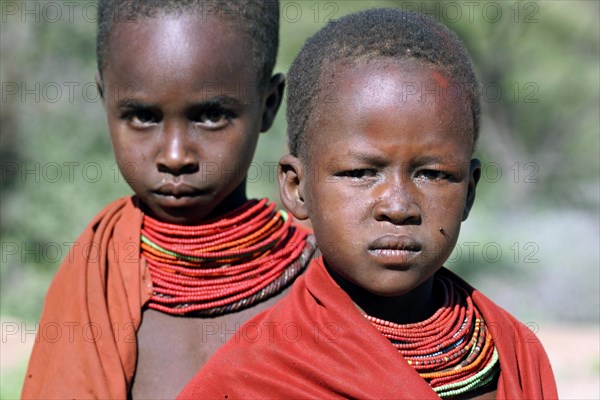 Portrait of two Turkana children in traditional red clothing in northwest Kenya