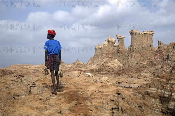 Black man of the Afar tribe and towers and pinnacles composed of salt