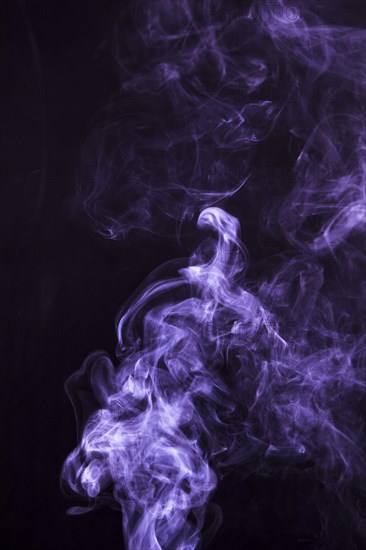 Soft focus smoke swirling black background